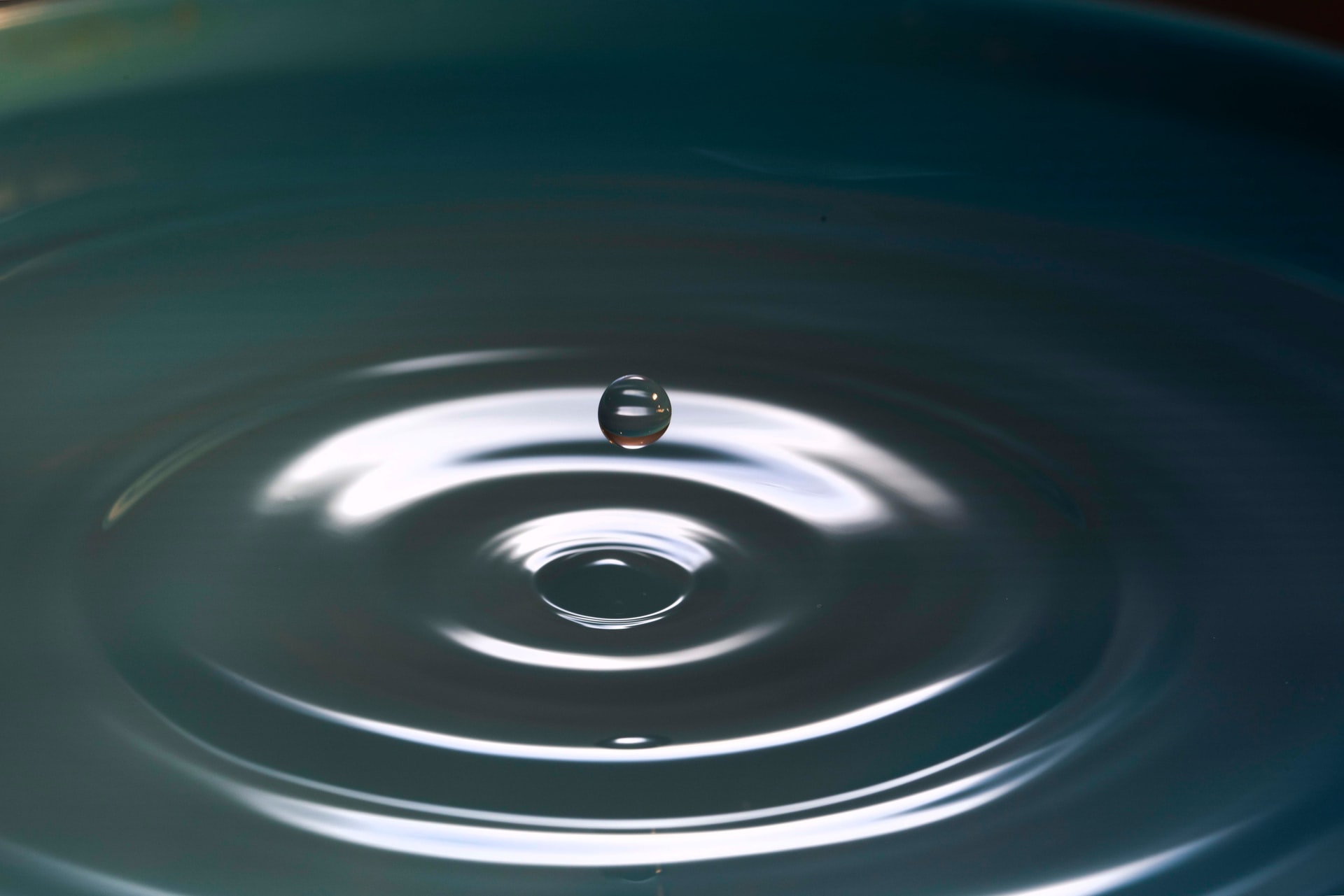 Drop of water bouncing off a rippled pond